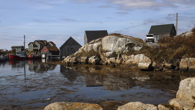 En california kører langs en kyst med en lille havn og nogle huse
