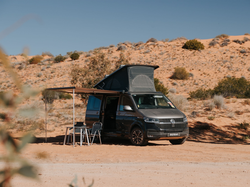 VW Camper van with roof tent and gazebo in desert 