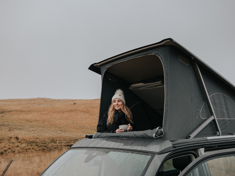 Girl sat in campervan roof tent