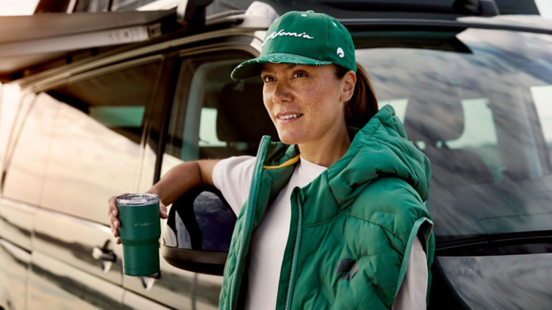 Frau in California Lifestyle Bekleidung am geöffneten Volkswagen Fahrzeug