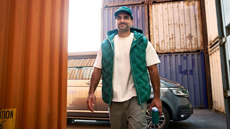Mann in California Lifestyle Bekleidung vor einem Volkswagen Fahrzeug