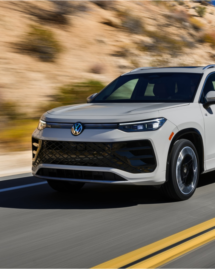 Un SUV blanco de VW circula por una autopista en un paisaje desértico.
