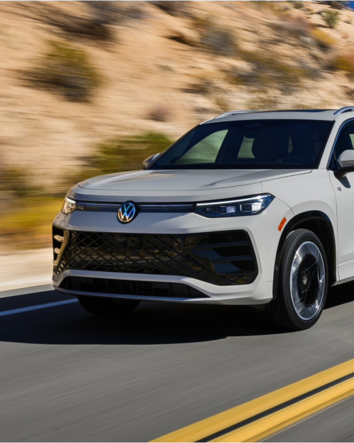 Un SUV blanco de VW circula por una autopista en un paisaje desértico.