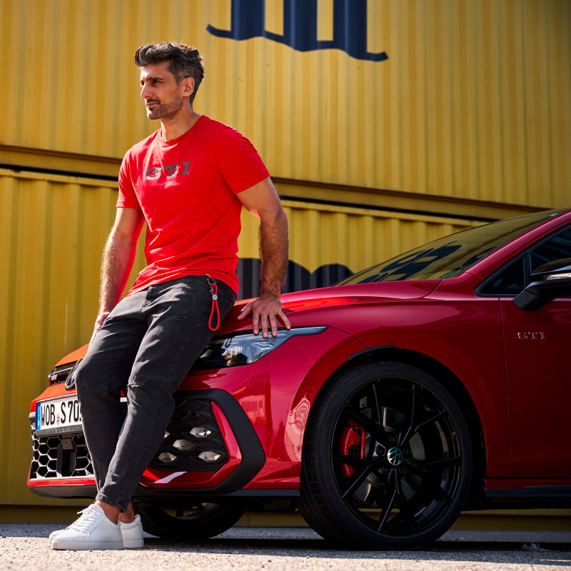 Vista di un uomo con addosso la T-Shirt rossa con scritta GTI nella parte frontale.