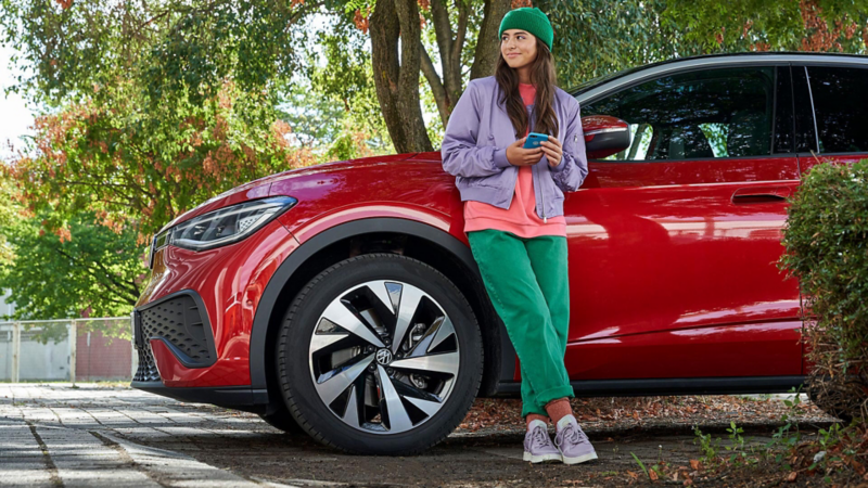 Woman leaning against red VW
