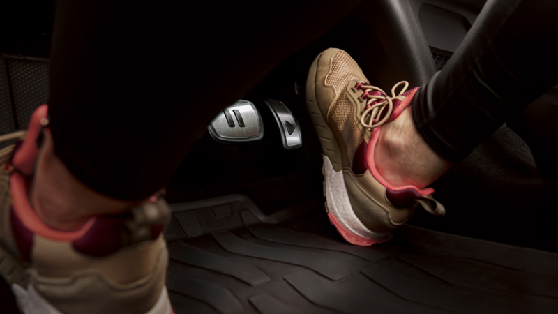 Fußraum mit Blick auf Gas- und Bremspedal in einem VW ID.; ein Fuß bewegt sich auf das Gaspedal zu.