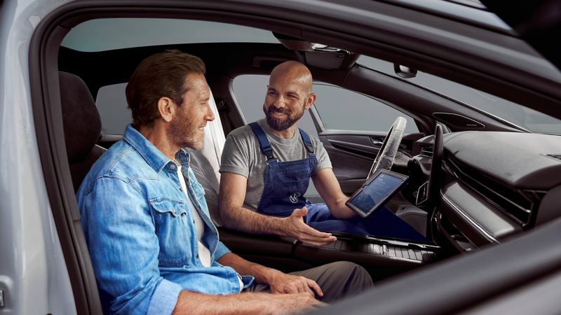 a VW van expert talking to an owner in the front seat of an EV van