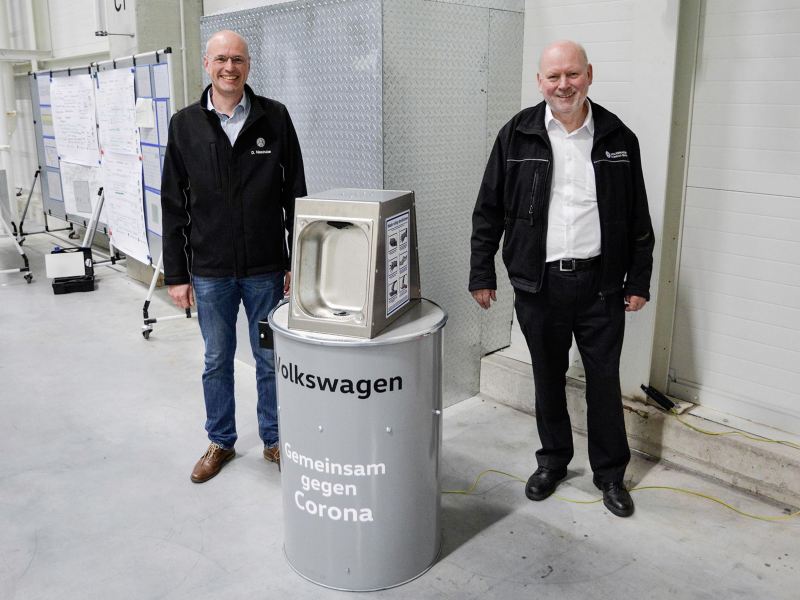 VW Mitarbeiter zeigen Desinfektionsmittelspender gegen Corona im VW Werk Emden