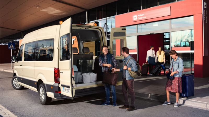 Deux messieurs entrain de charger leurs bagages dans le Crafter volkswagen