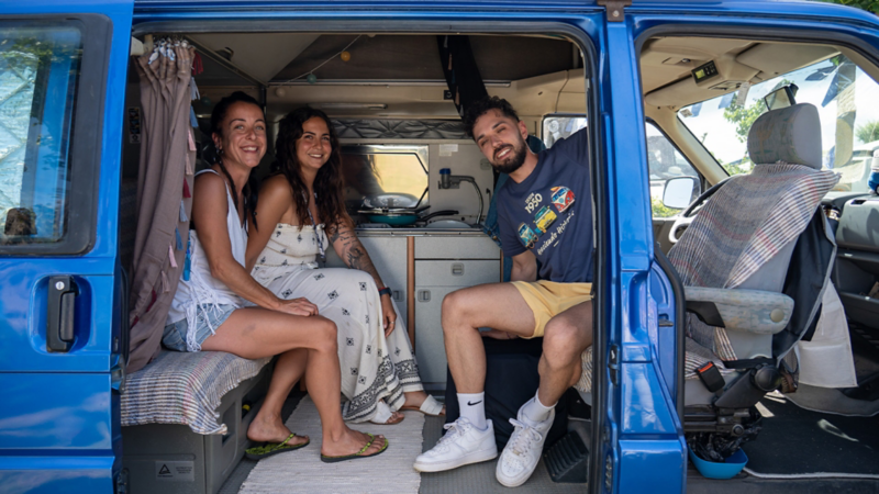 Tres jóvenes sentados en el interior de un VW California.