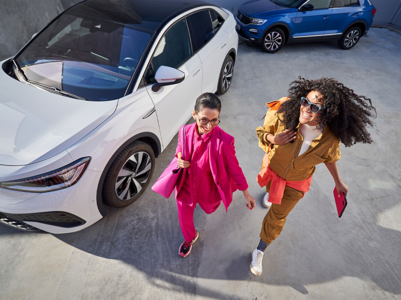 Two women stood next to VW car