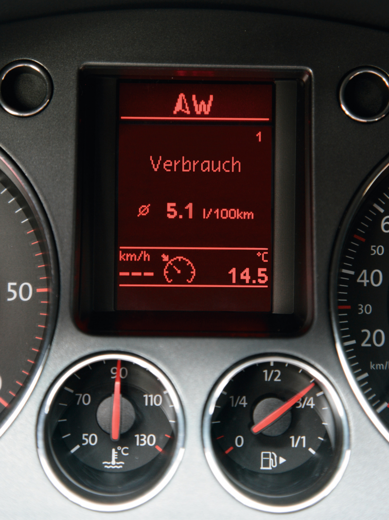 Instrumentpanel i en Volkswagen som visar genomsnittlig bränsleförbrukning, yttertemperatur samt analoga mätare för motor- och bränslenivåer.