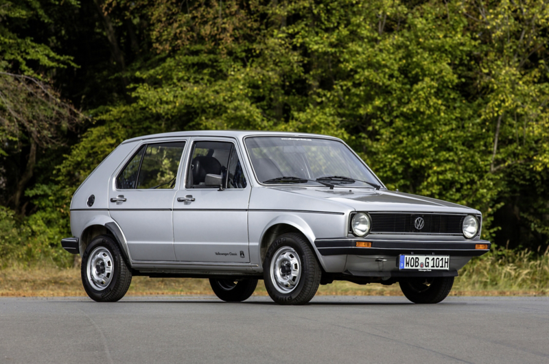 Volkswagen Golf Mk1 i silver, fotograferad från sidan på en väg med skog i bakgrunden