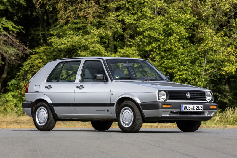 Volkswagen Golf Mk2 i silver, fotograferad från sidan på väg med skog i bakgrunden