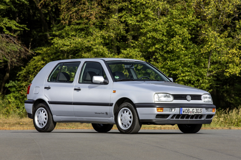 Volkswagen Golf Mk3 i silver, fotograferad från sidan på väg med skog i bakgrunden