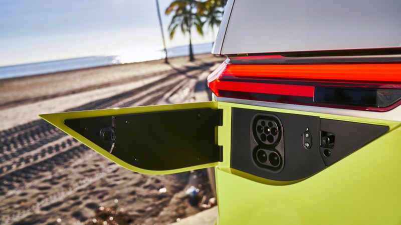The electric charging port of the Volkswagen I.D. BUZZ with views of the oceanfront in the background. 
