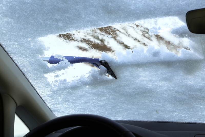 Vy inifrån en bil där framrutan är helt täckt av snö