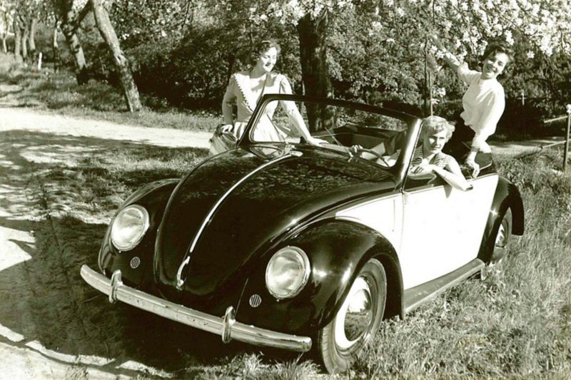 Drie vrouwen zitten in een Volkswagen Beetle Cabrio