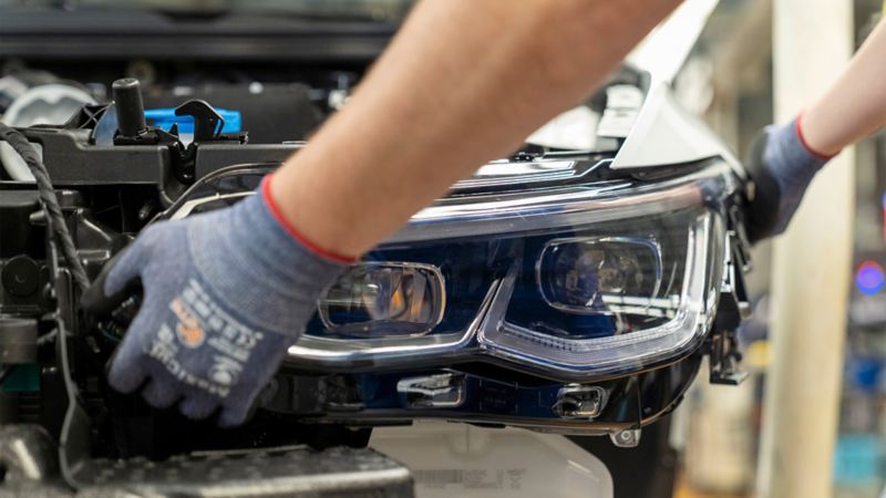 A pair of hands fitting a headlight