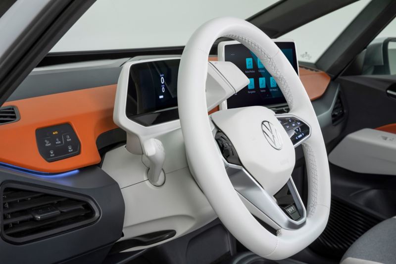 Interni di Volkswagen ID.3, in versione chiara, con dettaglio sul volante e sul cruscotto.