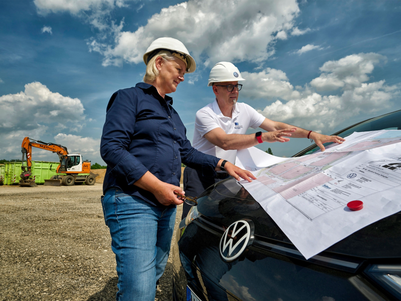 Image of two people looking at a site map placed on VW car