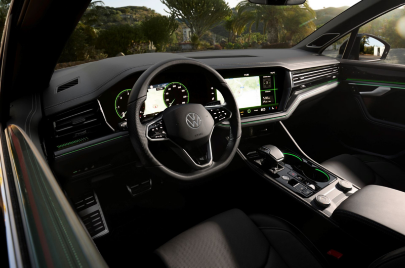 A VW Touareg Elegance at dusk by the sea with the IQ.LIGHT HD matrix headlights switched on. 