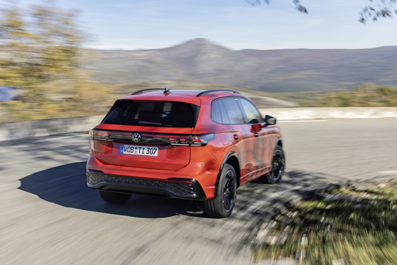 Röd Volkswagen sedd från sidan, står parkerad mot en vägg.