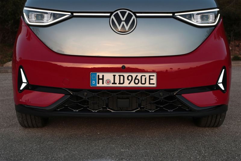 VW ID. Buzz GTX vu avant en zoom et phares allumés, gris et rouge