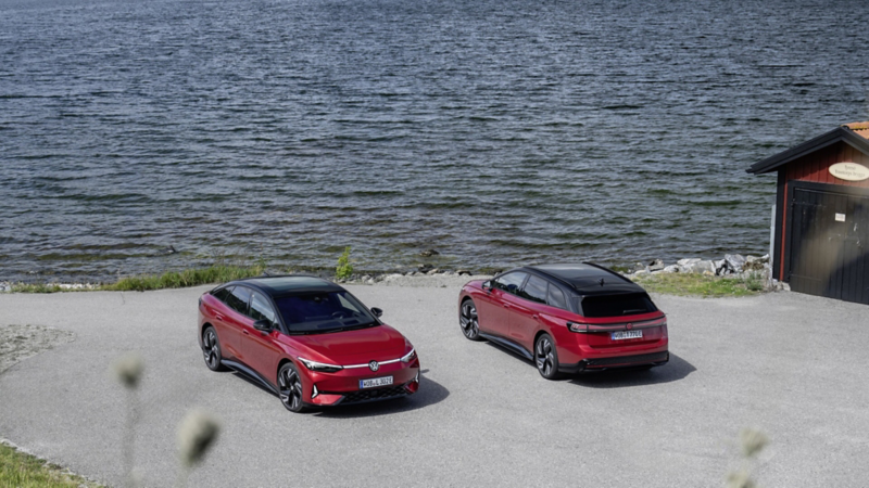 Två röda Volkswagenbilar parkerade precis vid havet