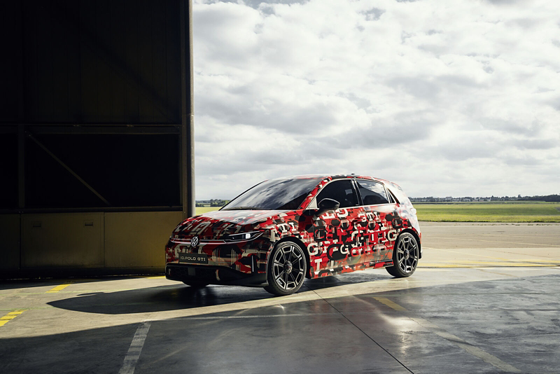 a red and grey ID. Polo GTI parked in a warehouse with cloudy skies in the background