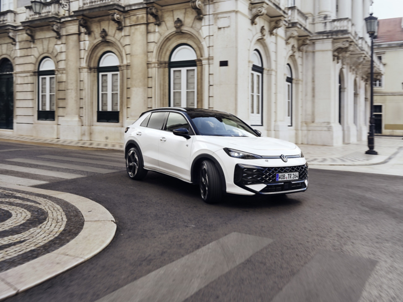 Vit Volkswagen T-roc kör inne i en stad.
