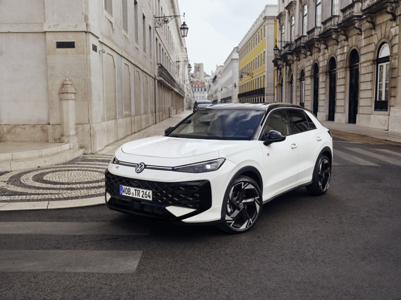 Vit Volkswagen T-Roc kör i en kurva i stan.