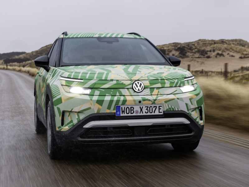 Frontansicht auf einen fahrenden VW ID. Cross mit Konzeptbeklebung auf einer Landstrasse.