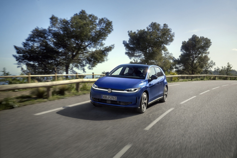 En blå VW ID. Polo körandes på en väg, fotad snett framifrån.
