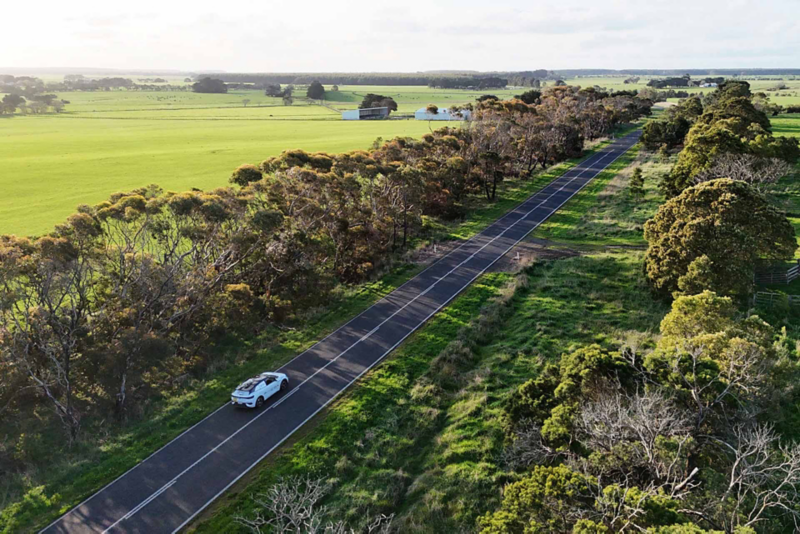 ID.4 driving on road with green fields surrounding road 