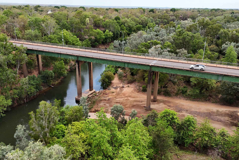 Ariel shot of ID.4 driving across bridge in forest