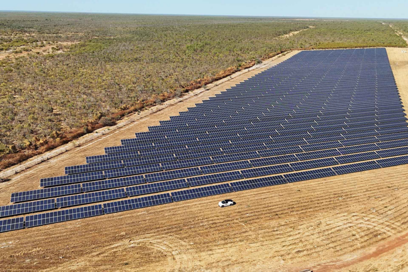 Ariel view of ID.4 driving through fields with solar panels next to it