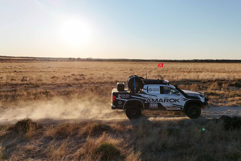 Side view of Amarok driving through flat desert land 