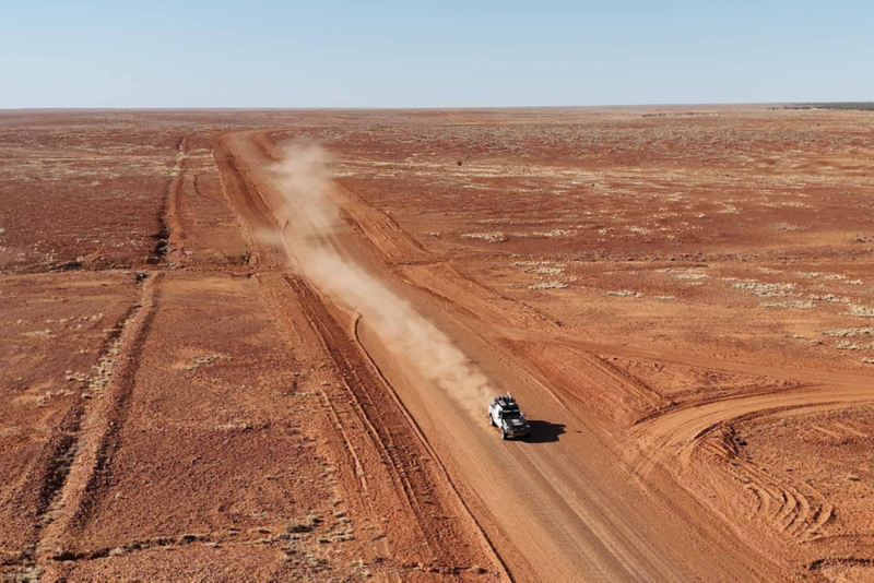 Amarok driving on desert road with dust plume behind