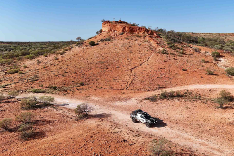 Front side ariel view of Amarok driving through the desert with rock terrain