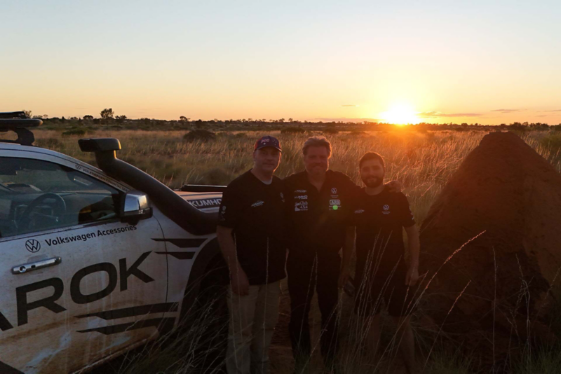 Team of 3 men stood next to Amarok at sunset