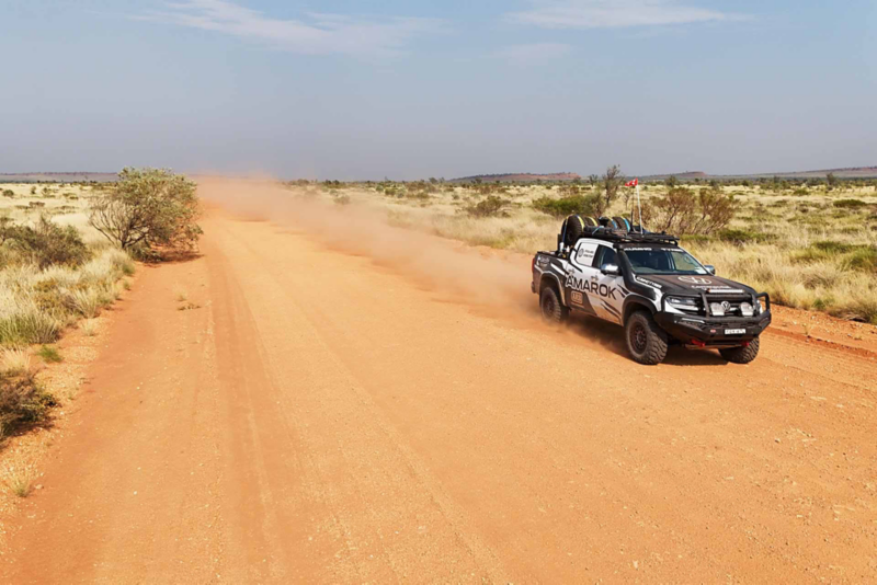 Front view of Amarok driving through desert creating dust plume