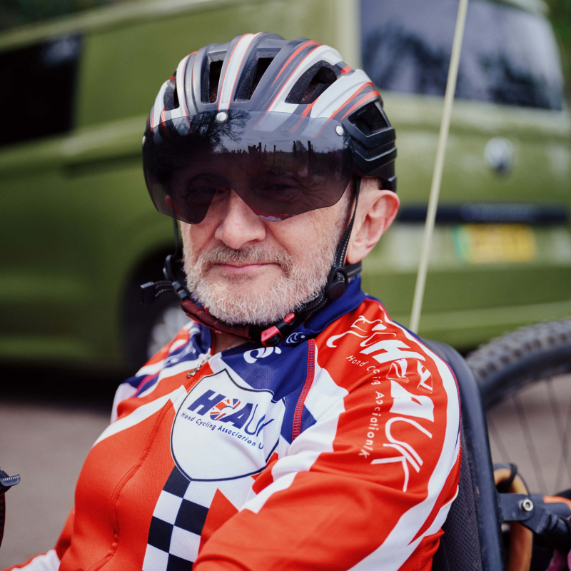 Close up picture of David Cooke with a helmet and sunshades on and an e-Transporter Kombi van in the background
