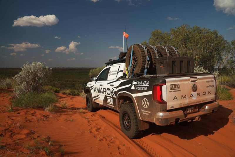 Rear view of Amarok driving off road through red desert terrain
