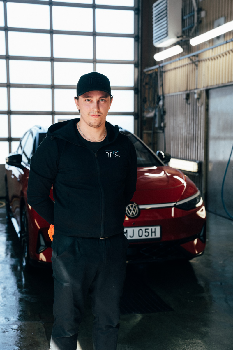 Bilvårdsexperten Rasmus Schäf står framför en röd ID.7 Tourer som han precis har tvättat