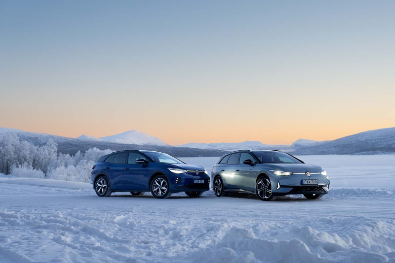 Två Volkswagen elbilar står parkerade i ett vinterlandskap