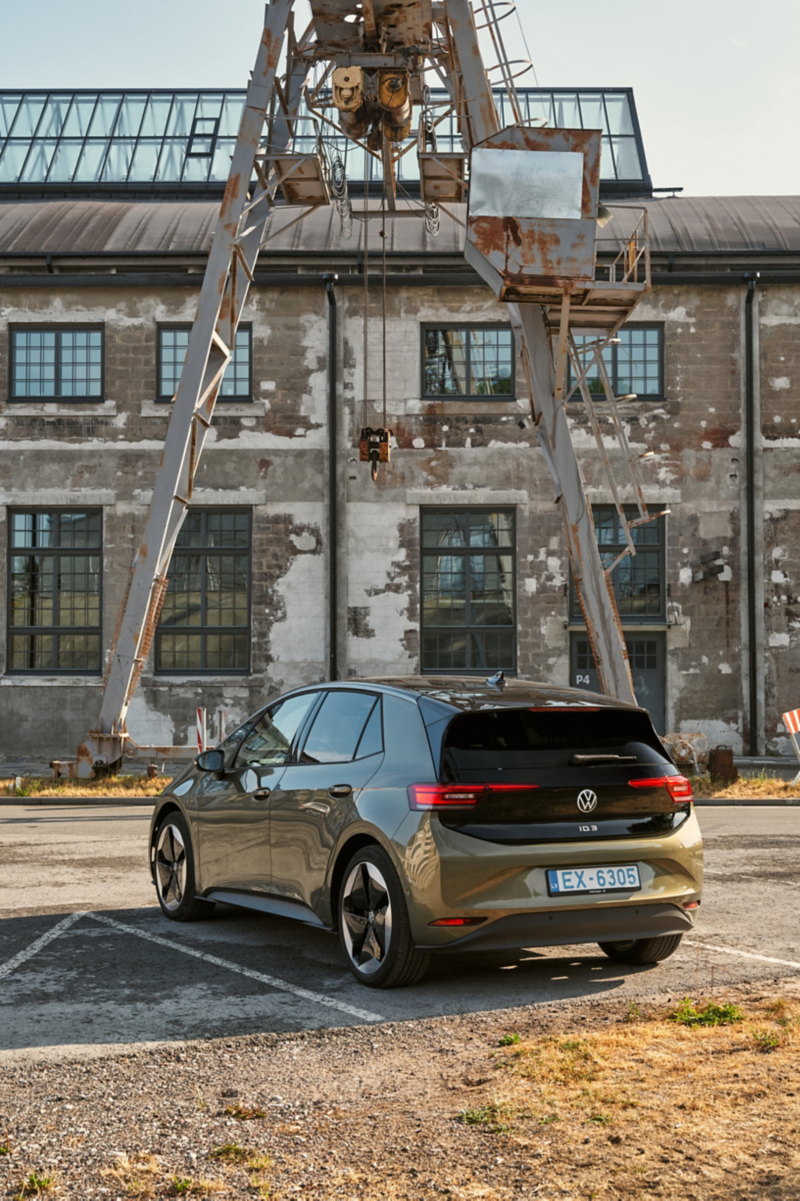 A view of a VW ID.3 parked in front of a garage and connected to a charging station.