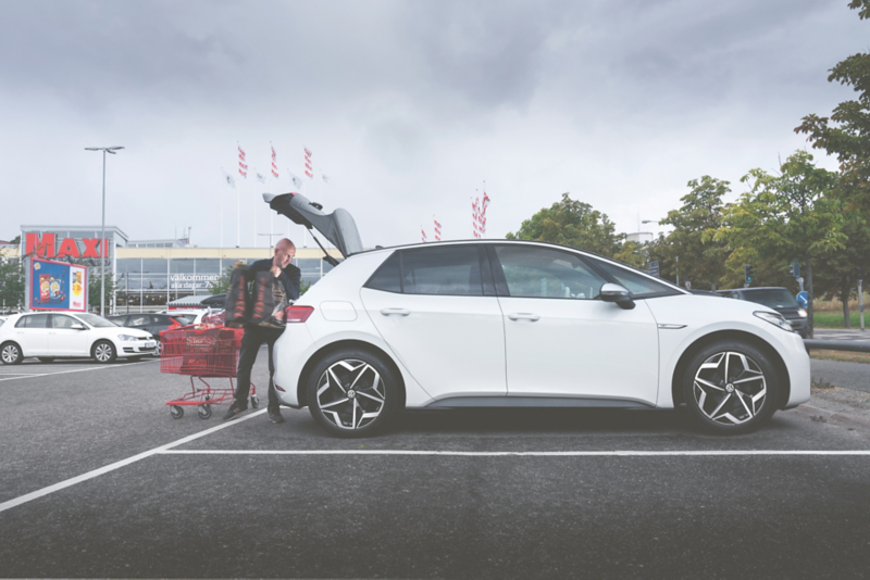 En vit Volkswagen ID.3 står parkerad utanför Ica Maxi, varor packas in i bagageutrymmet