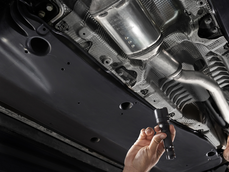 Mechanic searching underneath car conducting a DPF cleaning