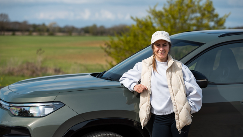 Ebba Andersson står framför en Volkswagen Tayron